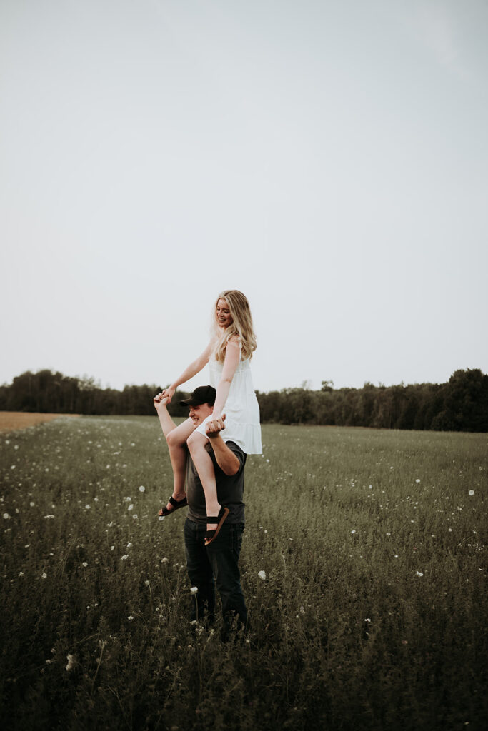 couple pose: a woman is sitting on a man's shoulder 