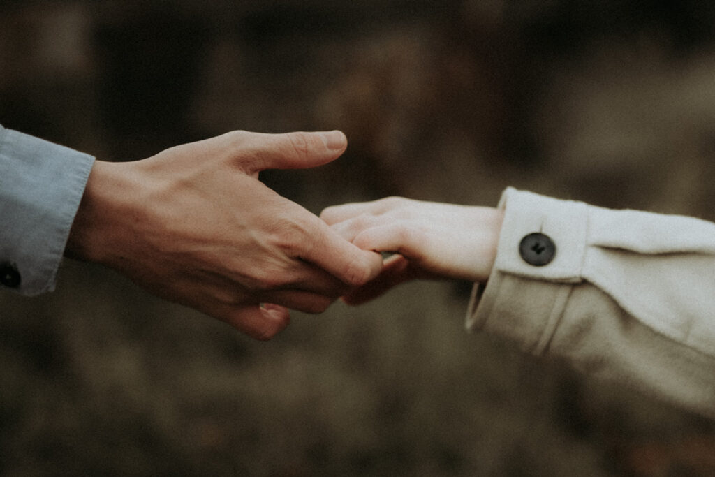 couple pose: a close up view of the couples hands tickling each others fingertips.