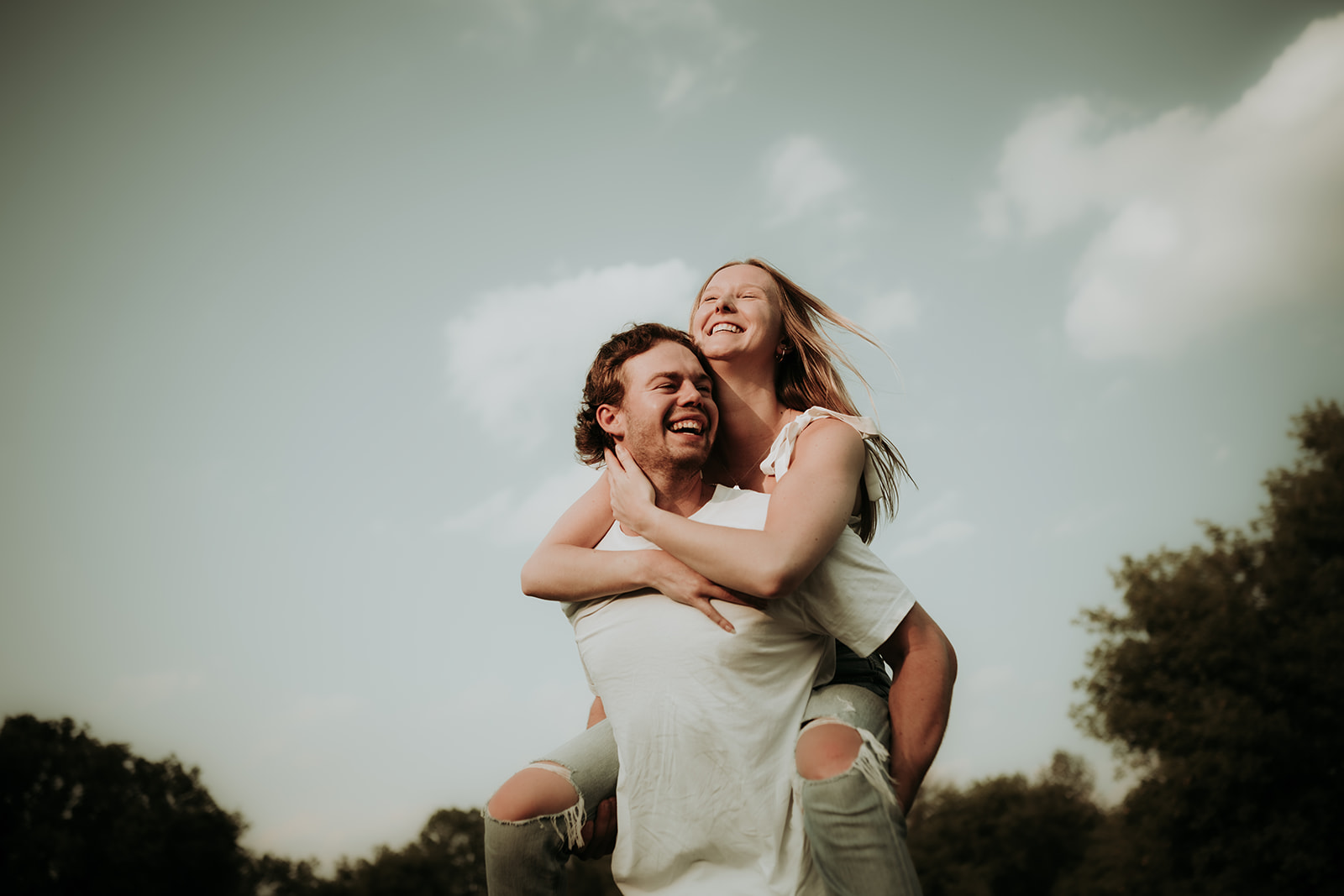 couple pose: a man carrying a woman on his back in a "piggyback" pose.