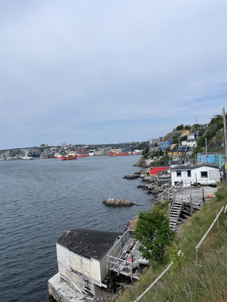 Start of Signal Hill Historic Trail in St. John’s, Newfoundland, with family walking up narrow road near Battery Road trailhead.
